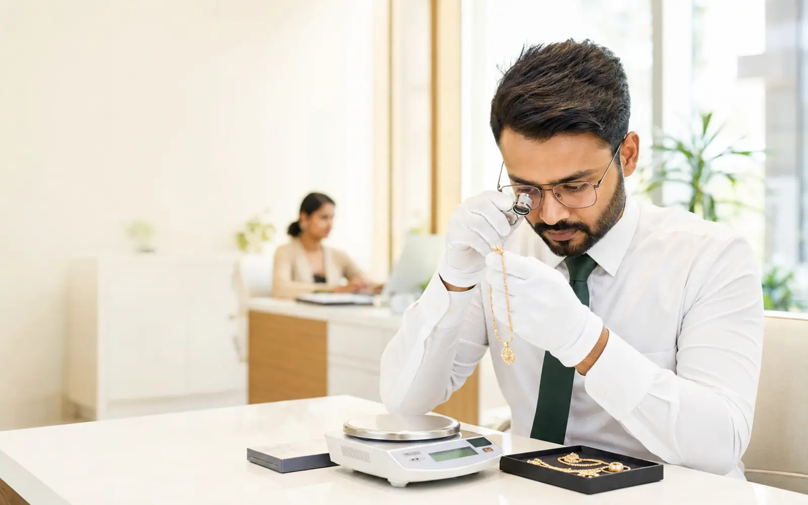 Professional gold evaluator inspecting jewellery in a bright Bengaluru office